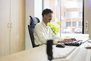 Office Interior Design Drucke: A professional works at a computer in a modern office setting