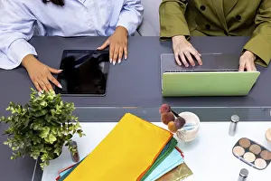 Professional Collaboration Drucke: Two professionals collaborate using technology devices