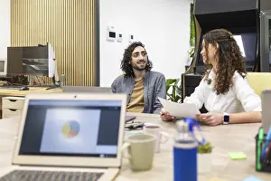 Business Teamwork Drucke: Professionals engaging in a collaborative discussion in a modern open-plan office