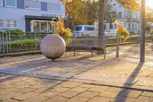 Deserted German Square Drucke: Public bench and large sphere on paved square