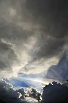 Low Angle Cloud View Drucke: Rain clouds with sun breaking through