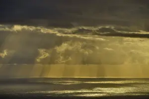 Deserted Beach Italy Drucke: Rain clouds with sun rays over the sea