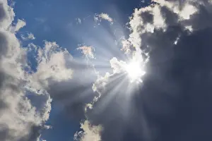 Cloudy Sky With Sunlight Drucke: Rain clouds with sun shining through
