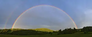 Deserted German Countryside View Drucke: Rainbow in a hilly landscape with forest