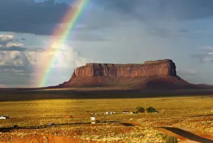 Eroded Landscape Of America Drucke: Rainbow at Monument Valley, cloudy sky