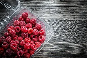 Fresh Raspberries Drucke: Raspberry in container on wooden board