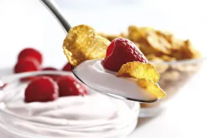 Close Up Breakfast Food Drucke: Raspberry yoghurt with cornflakes on a spoon