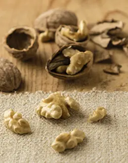 Deserted Table Scene Drucke: Raw brown broken natural rustic walnuts on table
