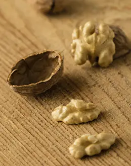 Deserted Table Scene Drucke: Raw brown broken natural rustic walnuts on table