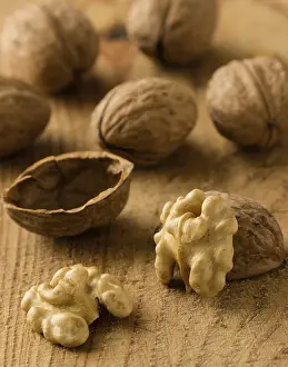 Deserted Table Scene Drucke: Raw brown broken natural rustic walnuts on table