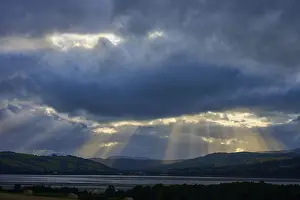 Mountainous European Landscapes Drucke: Rays of light break through dramatic clouds over a lake and mountain landscape