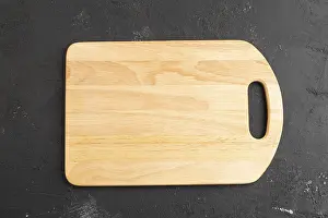 Black Concrete Background Drucke: Empty rectangular wooden cutting board on black concrete background