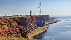 Lighthouse Germany Drucke: Red cliffs with lighthouse under blue sky on the coast
