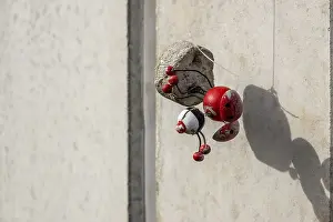 Urban Art Installation Drucke: Red decorative object with shadow on bright facade