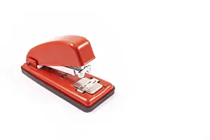 White Background Stationery Drucke: Detail of a red handheld stapler on a white background