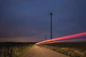 Ecofriendly Wind Power Drucke: Red light of a car pictured in a field