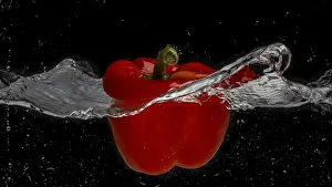 Paprika Plant Images Drucke: A red pepper falls through a water surface and creates a vortex