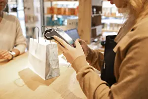 Retail Worker Drucke: A retail worker processes a transaction at a cosmetics store