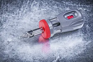 Metallic Background Concept Drucke: Reversible screwdriver on metallic background construction concept