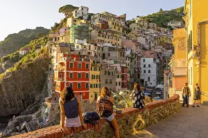 Drucke von Riomaggiore, Cinque Terre, Italien - 26. Juni 2018: Touristen betrachten das Stadtpanorama von Riomaggiore während der goldenen Sonnenuntergangsstunde Verwandte Bilder Drucke: Riomaggiore, Cinque Terre