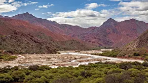 Colorful Rock Formations Drucke: River flows through red mountains with clouds in the sky