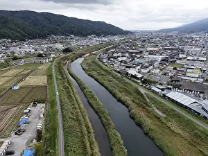 Uninhabited Town View Drucke: A river runs through a city with a bridge over it