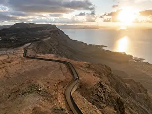 Rocky Shoreline At Sunset Drucke: Road on cliffs in evening light