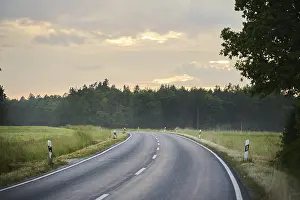 Southern Germany Weather Forecast Drucke: Road through fields and forests at sunset after rain