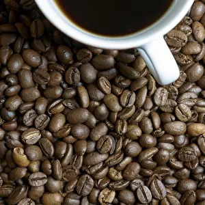 Caffeine Rich Beverage Drucke: Roasted coffee beans and a cup of coffee on a table