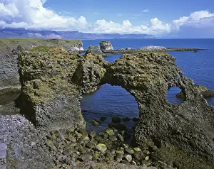 Volcanic Island Landscape Drucke: Rock gate at the cliffs formed by volcanic basalt columns in Arnarstapi