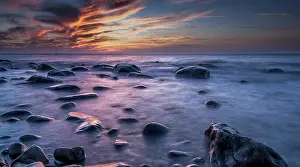 Northern Germany Waterfront Drucke: Rocks on a beach at sunset by the sea