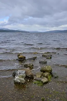 Drucke von Felsen am Ufer eines Sees mit kleinen Wellen unter einem wolkenverhangenen Himmel, Loch Rannoch, Kinloch Rannoch, Schottland, Vereinigtes Königreich, Großbritannien See Drucke: Felsen am Ufer eines Sees mit kleinen Wellen unter einem bewölkten Himmel.