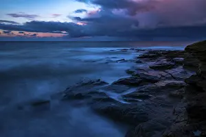 Cloudy Atmospheric Landscape Drucke: Rocky coast with dramatic dark clouds at sunset