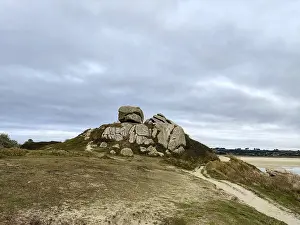 Uninhabited Rocky Shoreline Drucke: A rocky hill with a path under a grey sky