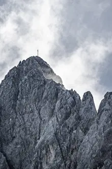 Wetterstein Mountains Bavaria Drucke: Rocky summit with summit cross between clouds