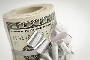One Hundred Dollar Bill Drucke: Roll of one hundred dollar bills with silver bow on white