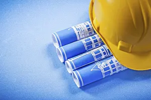 Hard Hat Safety Helmet Drucke: Rolled up construction plans hard hat on blue background
