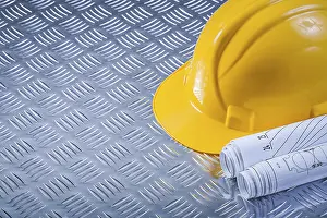 Hard Hat Studio Shot Drucke: Rolled engineering drawings hard hat on fluted metal background construction concept