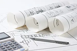 Construction Planning Drucke: Rolled technical drawings and a calculator