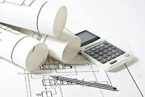Construction Planning Drucke: Rolled technical drawings and a calculator