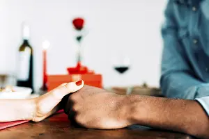 Intimate Atmosphere Drucke: A romantic dinner setting features a couple holding hands across a table