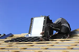 Residential Building Renovation Drucke: Roofer works on the chimney cladding