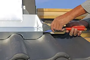 Residential Building Renovation Drucke: Roofer works on the chimney cladding