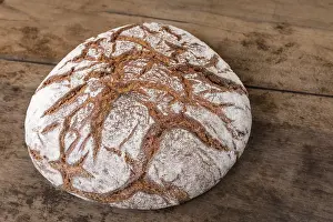 Wholemeal Bread Nutrition Drucke: Round rye bread with a crispy crust and flour on an old table