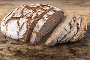 Old Table Setting Drucke: Round rye bread with a crispy crust and flour on an old table
