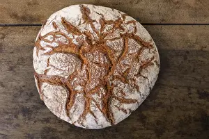 Old Table Setting Drucke: Round rye bread with a crispy crust and flour on an old table