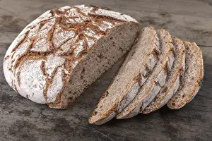 French Baked Goods Drucke: Round rye bread with a crispy crust and flour on an old table