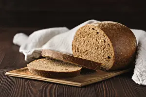Natural Nutrition Drucke: Rue brown bread on cutting board on the table