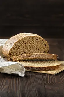 Black Table Setup Drucke: Rue brown bread on cutting board on the table