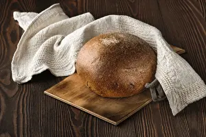 Natural Nutrition Drucke: Rue brown bread on cutting board on the table